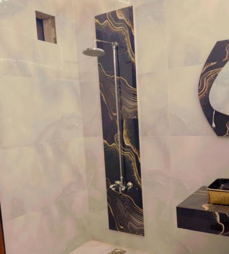 a shower with a black and gold design on a wall at Sapphire Guest House in Karachi