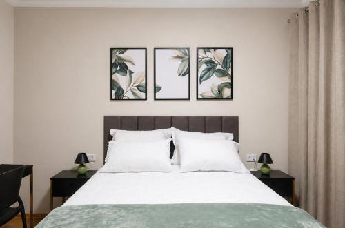 a bedroom with a bed with four pictures on the wall at Flórida vivo bem! in São Roque