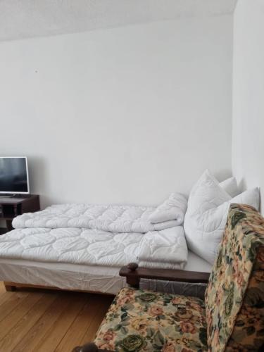 a white couch in a living room with a tv at Apartament Centrum Zgorzelec in Zgorzelec