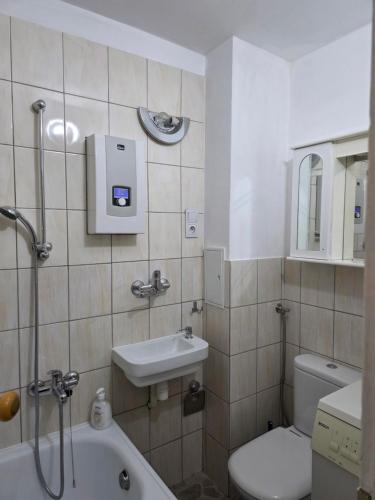 a bathroom with a sink and a toilet and a tub at Apartament Centrum Zgorzelec in Zgorzelec
