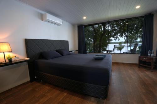a bedroom with a bed and a large window at Yguazú Resort - Cabañas & Camping in Juan E. Oʼleary