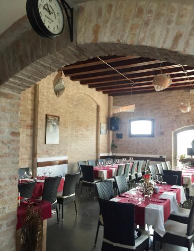 a dining room with tables and chairs and a clock at RESIDENCE BACO Da SETA in Mestre