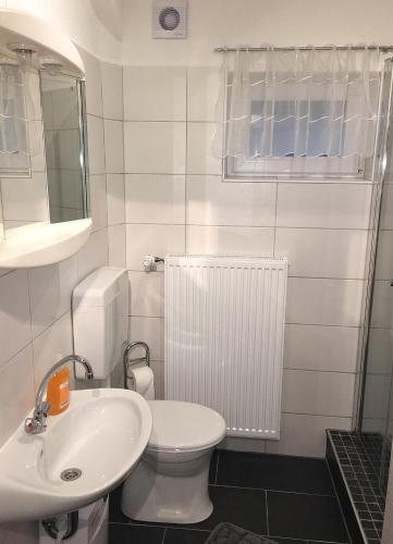 a white bathroom with a sink and a toilet at Ferienwohnung Neuber in Bad Kissingen