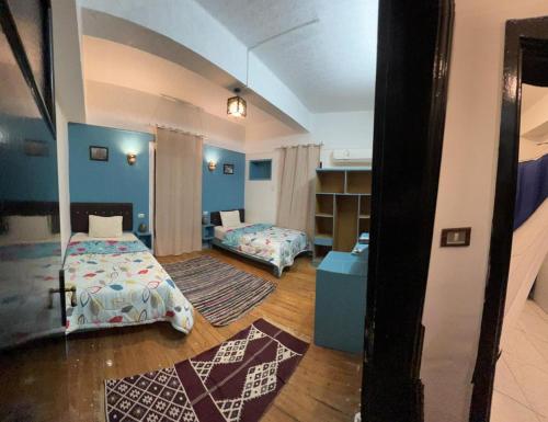 a bedroom with two beds in a room with blue walls at happy life hostel in Cairo