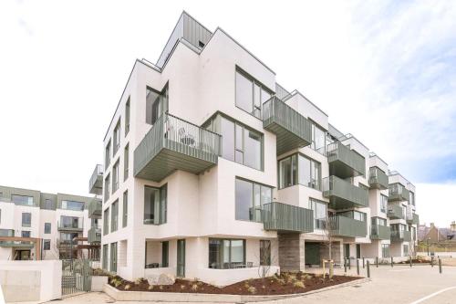 a white building with balconies on the side of it at Apex Executive Apartments - The Lookout in Dublin