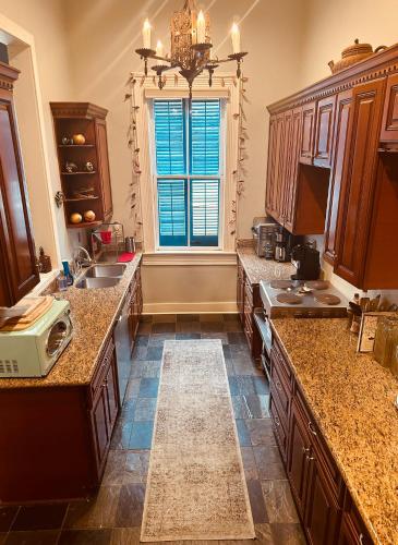 a large kitchen with a sink and a window at The Dragonfly Tremé-Historic Guesthouse-Near French Quarter in New Orleans