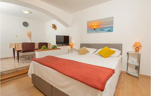 a bedroom with a bed and a table and a television at Cozy Apartment In Jadranovo in Jadranovo