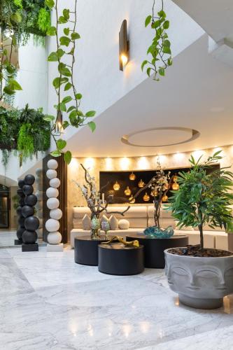 a lobby with potted plants and a couch at Hotel Posada San Antonio in Reynosa