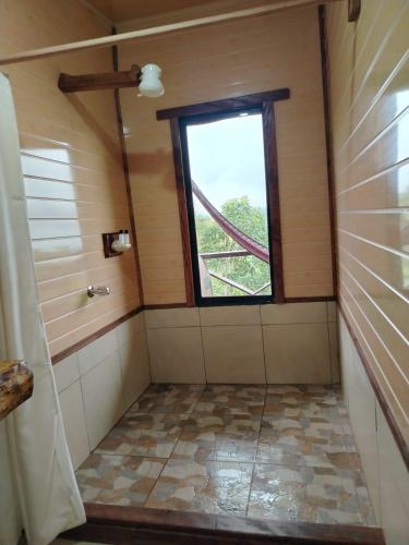 a bathroom with a window and a tiled floor at Cielo nocturno Perez Zeledon in Berlín