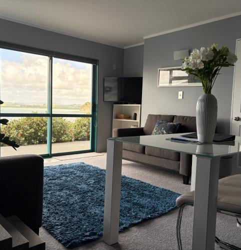 a living room with a table and a couch at Beach Lane Apartment in Whangarei