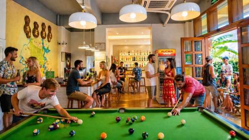 a group of people playing pool in a bar at Yangshuo Eden's Social Guesthouse - cozy garden courtyard & fresh craft coffee & night beers & outdoor activities in Yangshuo