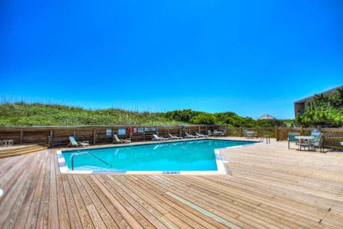 a swimming pool on a wooden deck with a wooden floor at QCB5 - Saltaire Sunrise in Nags Head
