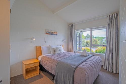 a small bedroom with a bed and a window at Andorra Motel in Geraldine