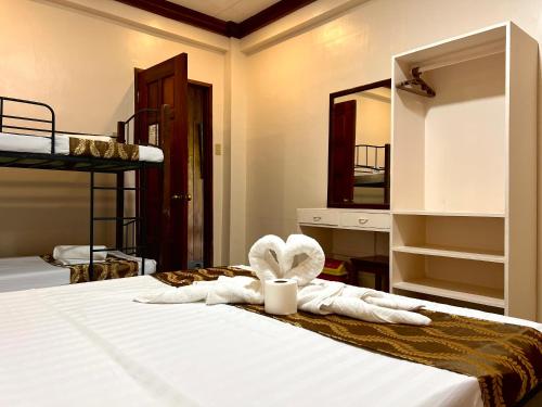 a bedroom with a bed with towels and a mirror at Sequor Palm Villa in Siquijor