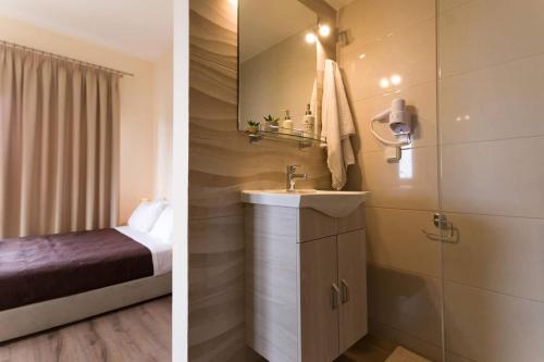 a bathroom with a bed and a sink in a room at Hawaii Accommodation Pelekas in Pelekas