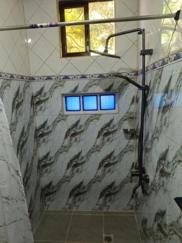 a bathroom with a shower with blue lights in it at Casa Maria in Sibulan
