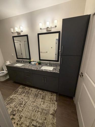 a bathroom with two sinks and two mirrors at Cozy Comfortable Apartment in Atlanta in Atlanta