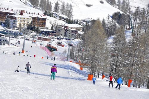 a group of people skiing down a snow covered slope at Appartamento Bianco in Borgata Sestriere