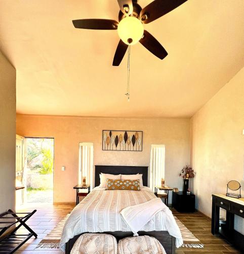 a bedroom with a bed and a ceiling fan at The Bungalow @Terra Monarca in El Porvenir