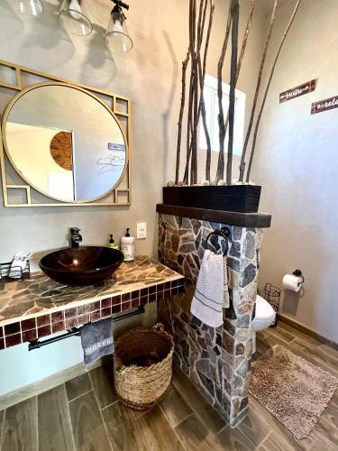a bathroom with a sink and a mirror at The Bungalow @Terra Monarca in El Porvenir
