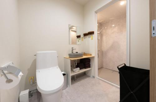 a bathroom with a white toilet and a shower at くらしホテル Hakodate in Hakodate