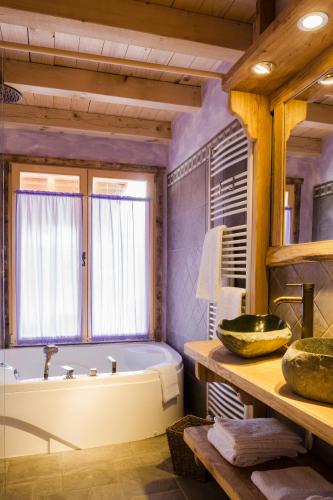 a bathroom with a tub and a window and a sink at Dolomiti Village in Comeglians