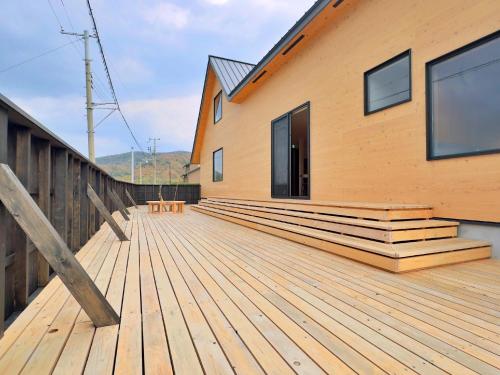 a wooden deck on a house with a building at Private Villa 蒼 Lala & Lino in Kyotango