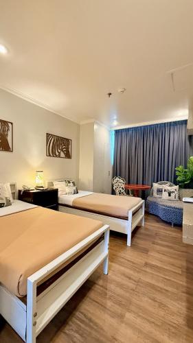 a hotel room with two beds and a window at Hotel Tiffany - Laoag in Laoag