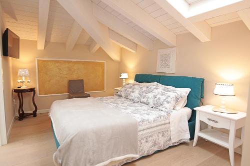 - une chambre avec un grand lit et une télévision dans l'établissement Dimora Valpolicella, à SantʼAmbrogio di Valpolicella