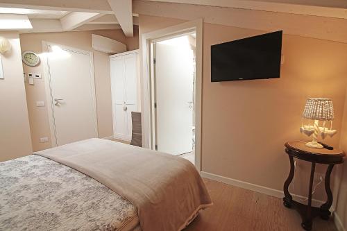 サンタンブロージョ・ディ・ヴァルポリチェッラにあるDimora Valpolicellaのベッドルーム1室(ベッド1台、壁掛けテレビ付)