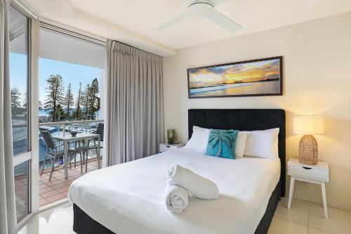 a bedroom with a bed and a balcony at Central Mooloolaba Beachfront Apartment - Located in Sandcastles Resort in Mooloolaba