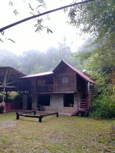 eine Blockhütte mit Veranda und Balkon in der Unterkunft Bosque de Niebla in Tlatlauquitepec