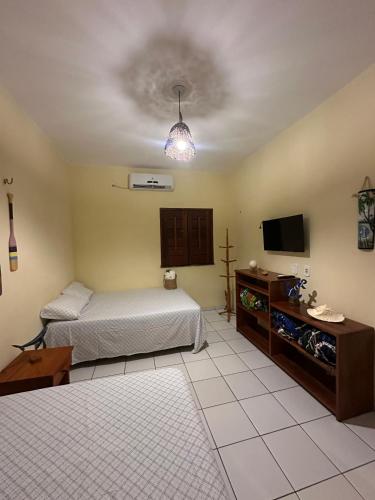 a bedroom with a bed and a tv on the ceiling at Rota do Mar in Luis Correia