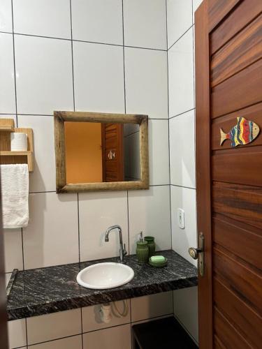 a bathroom with a sink and a mirror at Rota do Mar in Luis Correia