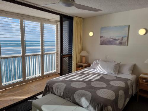 a bedroom with a bed and a large window at Gemini Unit 64 Golden Beach QLD in Golden Beach