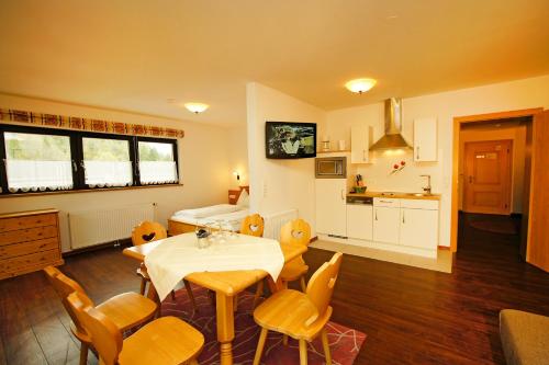 a living room with a table and chairs and a kitchen at Haus Hubertus in Wagrain