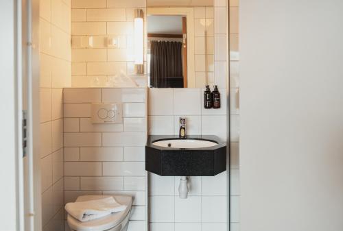 a bathroom with a sink and a toilet at Home Hotel With in Tromsø