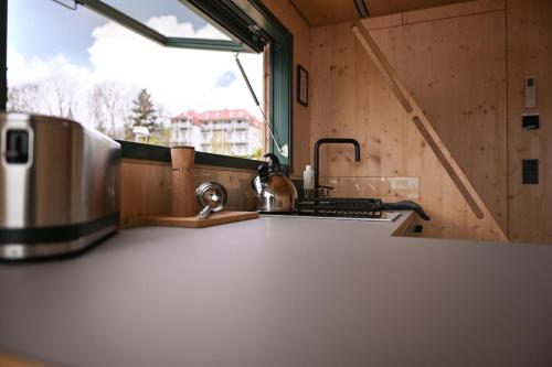 a kitchen with a counter with a sink and a window at Tiny House Nook 3 - Green&Tiny Hideaway Eider in Süderstapel