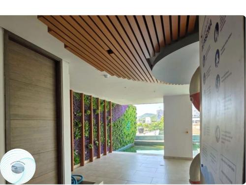 a house with a green wall in the hallway at Apartamento en el Rodadero, a pocos metros de la playa in Gaira