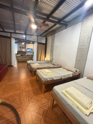 a room with four beds in a room with a ceiling at Cloudrest Marilog in Kayagan
