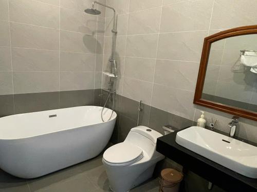 a bathroom with a tub and a toilet and a sink at Home Me 1 in Dong Hoi