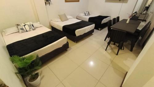 a room with two beds and a desk and a piano at Departamentos Céntricos en Lima in Lima