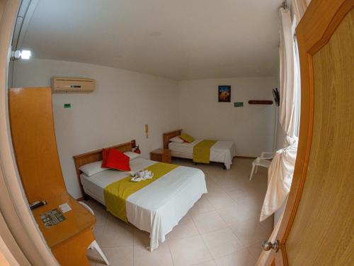 a hotel room with two beds and a window at Hotel BENNY Los Leones Melgar in Melgar