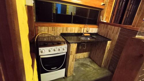 a small kitchen with a stove and a sink at Chalé dos ventos in Itamonte