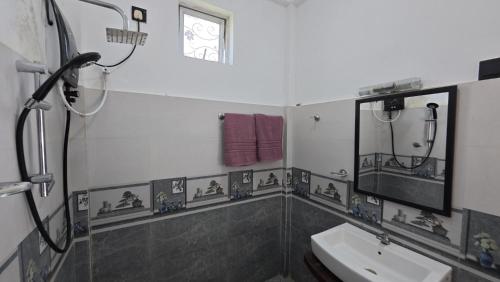 a bathroom with a sink and a mirror at Sewana Cottage in Kurunegala