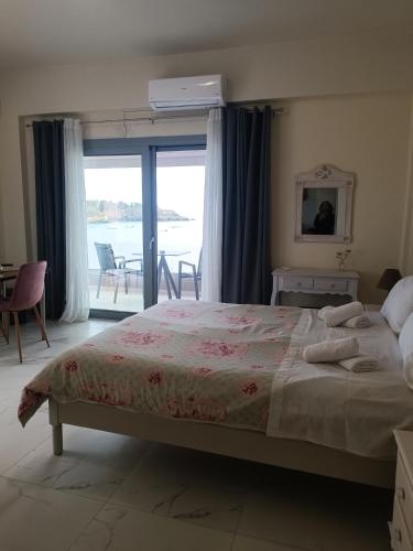 a bedroom with a bed and a view of the water at Buganvilla Sea View apts in Agia Pelagia