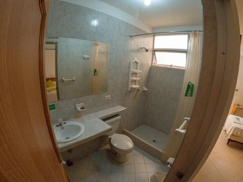 a bathroom with a sink and a toilet and a shower at Hotel BENNY Los Leones Melgar in Melgar