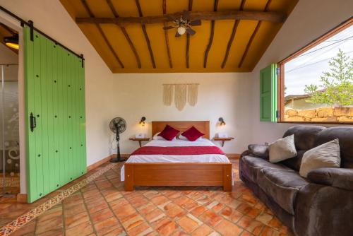 a bedroom with a bed and a couch at Cabañas Campestres El Vaticano in Barichara