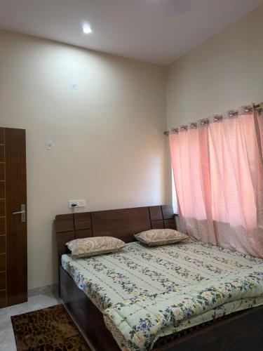 a bedroom with a bed and a window at Aura by bala in Dehradun