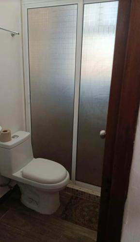 a bathroom with a toilet and a shower stall at Coastal Charm in Ixtapa